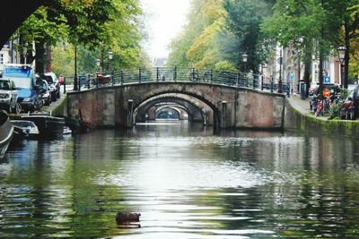 Bridge over river in city against sky