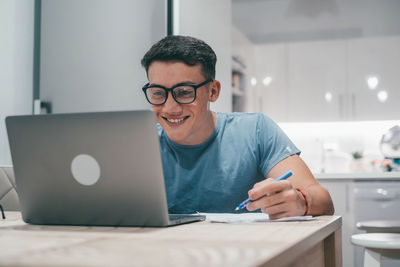 Young man using laptop at table