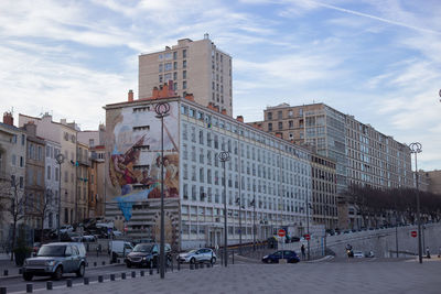 View of city street and buildings against sky