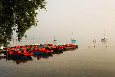 Boats moored in lake against clear sky