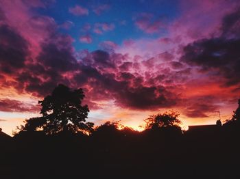 Low angle view of silhouette trees against sky at sunset