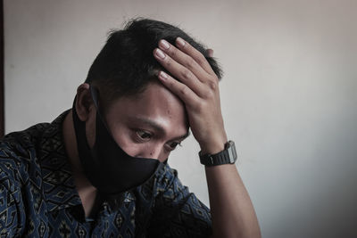 Portrait of young man against wall