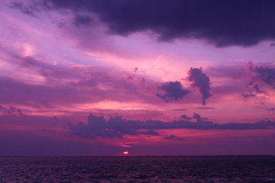 Scenic view of sea against dramatic sky during sunset