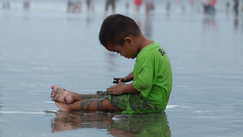 Side view of boy playing in lake