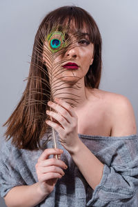 Portrait of woman holding hands against white background