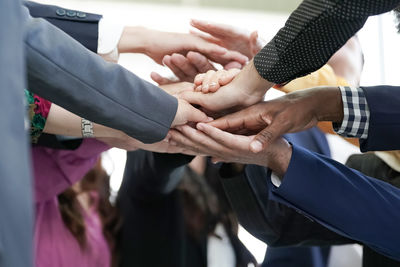 Midsection of people stacking hands