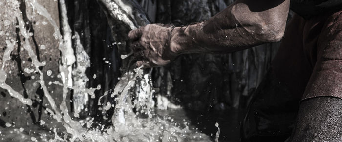 Cropped hand touching spraying water