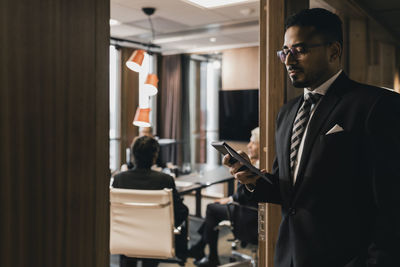 Young man using mobile phone in office