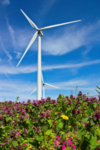 Low angle view of windmill against blue sky