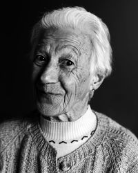 Portrait of old woman against black background