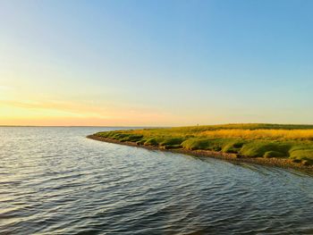 Scenic view of sea against clear sky during sunset
