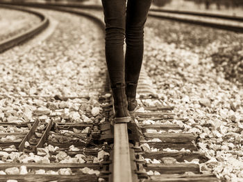 Low section of person standing on railroad track