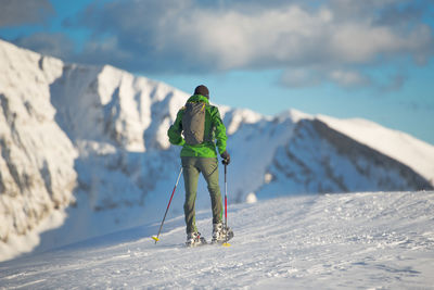 Rear view of person skiing on snowcapped mountain