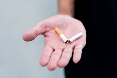 Close-up of hand holding cigarette