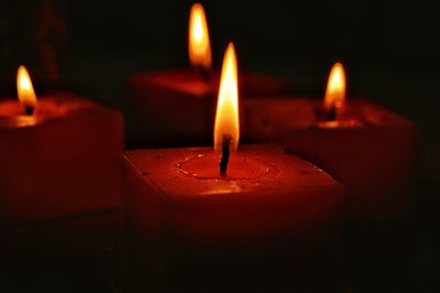 Close-up of lit candle in darkroom