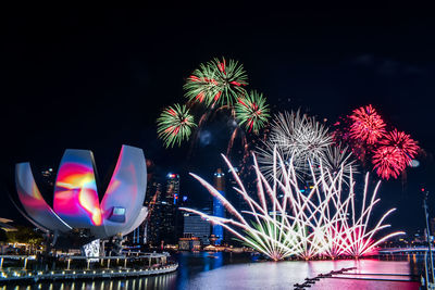 Firework display over river at night