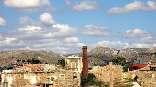 High section of houses and mountains against sky