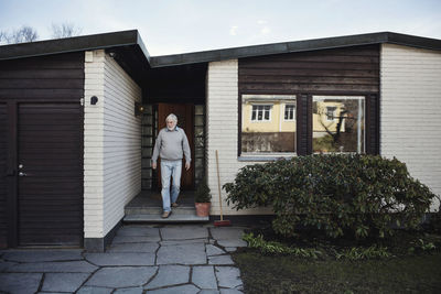 Full length of man standing outside house