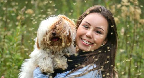 Portrait of smiling young woman holding dog