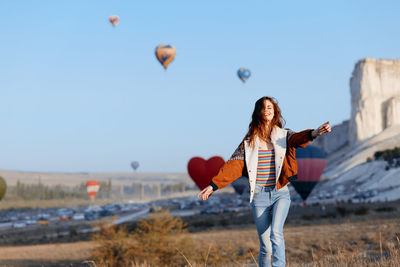 Rear view of woman standing against sky