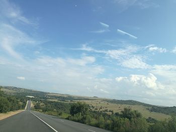 Road passing through landscape against sky