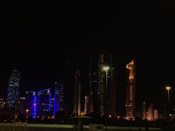 Illuminated buildings in city against sky at night