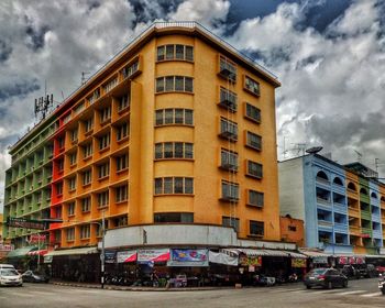 Buildings in city against cloudy sky