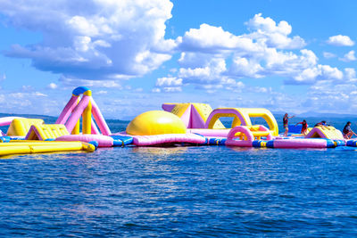 Multi colored boats in sea against blue sky