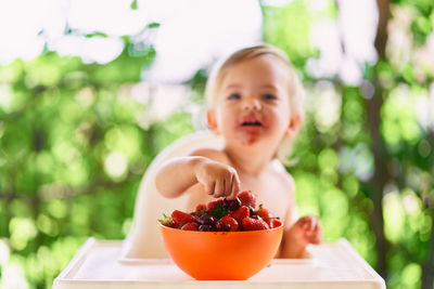 Girl eating fruit salad in bowl