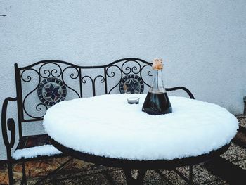 Empty chairs and tables on snow covered table during winter