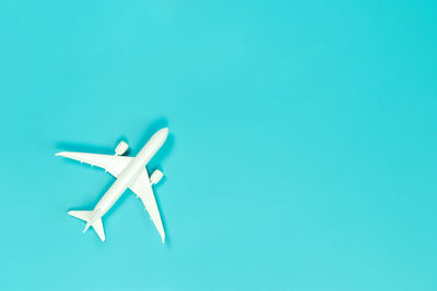 Close-up of airplane flying over blue background
