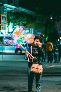 Woman with umbrella standing in city