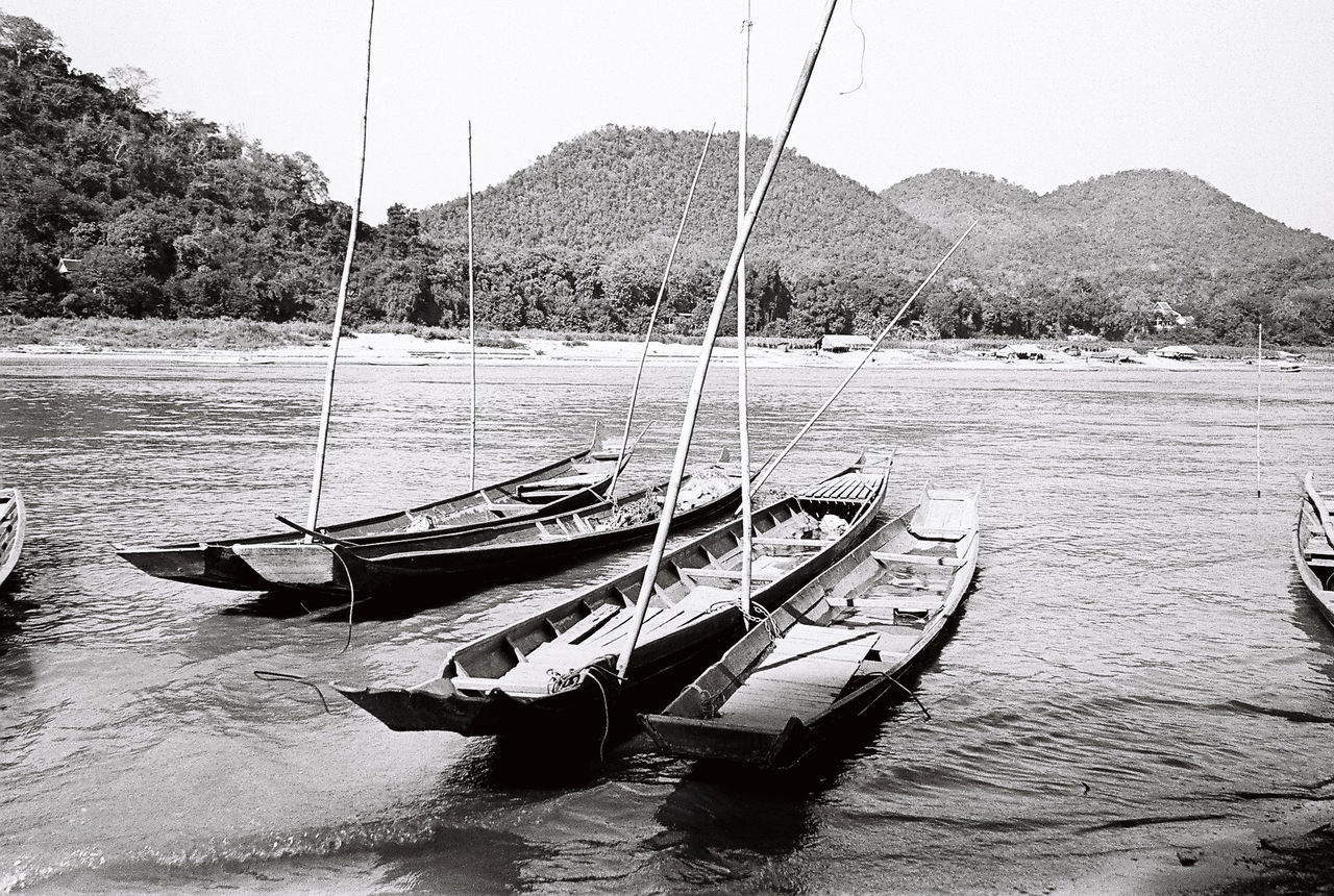 BOATS MOORED AT SEA AGAINST SKY