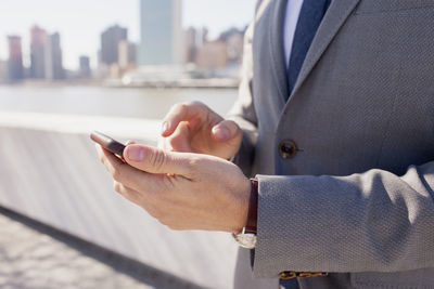 Close-up of a young businessman using his smartphone on a rooftop