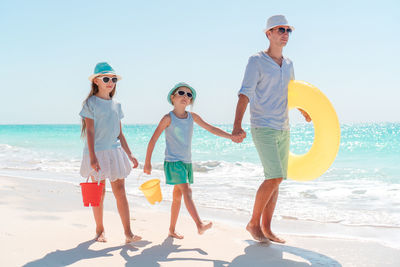 Father with daughters walking on beach