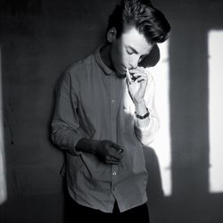 Young woman standing against wall