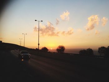Cars on road at sunset