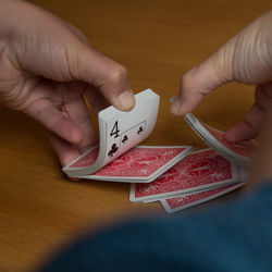 Cropped image of person shuffling cards on table