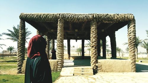 Rear view of woman standing against clear sky