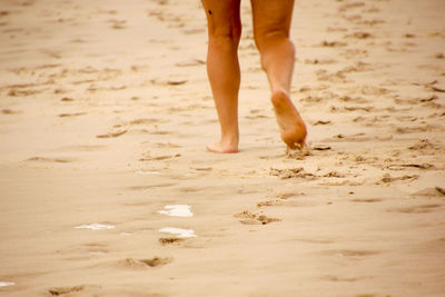 Low section of child standing on beach