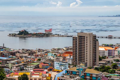 High angle view of buildings by sea against sky