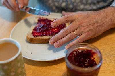 Man spread jelly on his bread