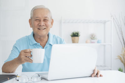 Portrait of man using laptop on table