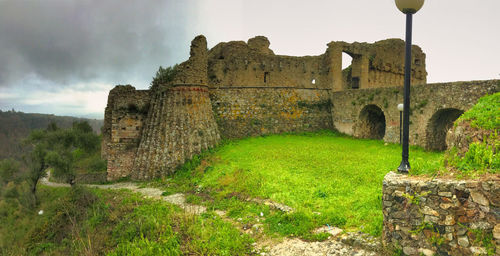 Old ruins on field against sky