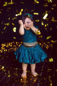 Girl in blue dress in studio with gold sequins and garland