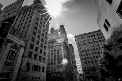 Low angle view of buildings in city during sunny day