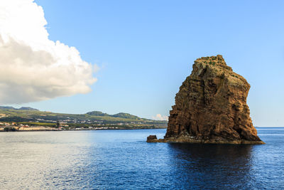 Rock formations in sea against sky