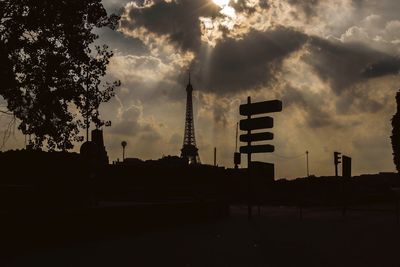 Silhouette cranes against sky during sunset