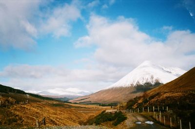 Scenic view of mountains against cloudy sky