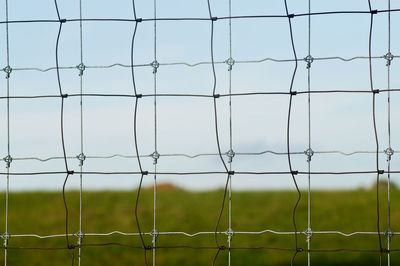 Close-up of chainlink fence against sky